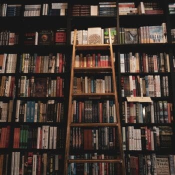 A Library with a ladder against the shelves of books