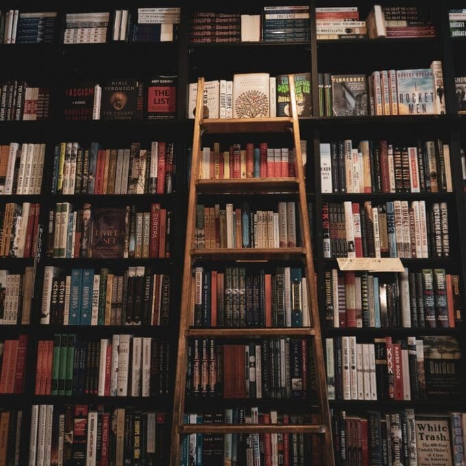 A Library with a ladder against the shelves of books